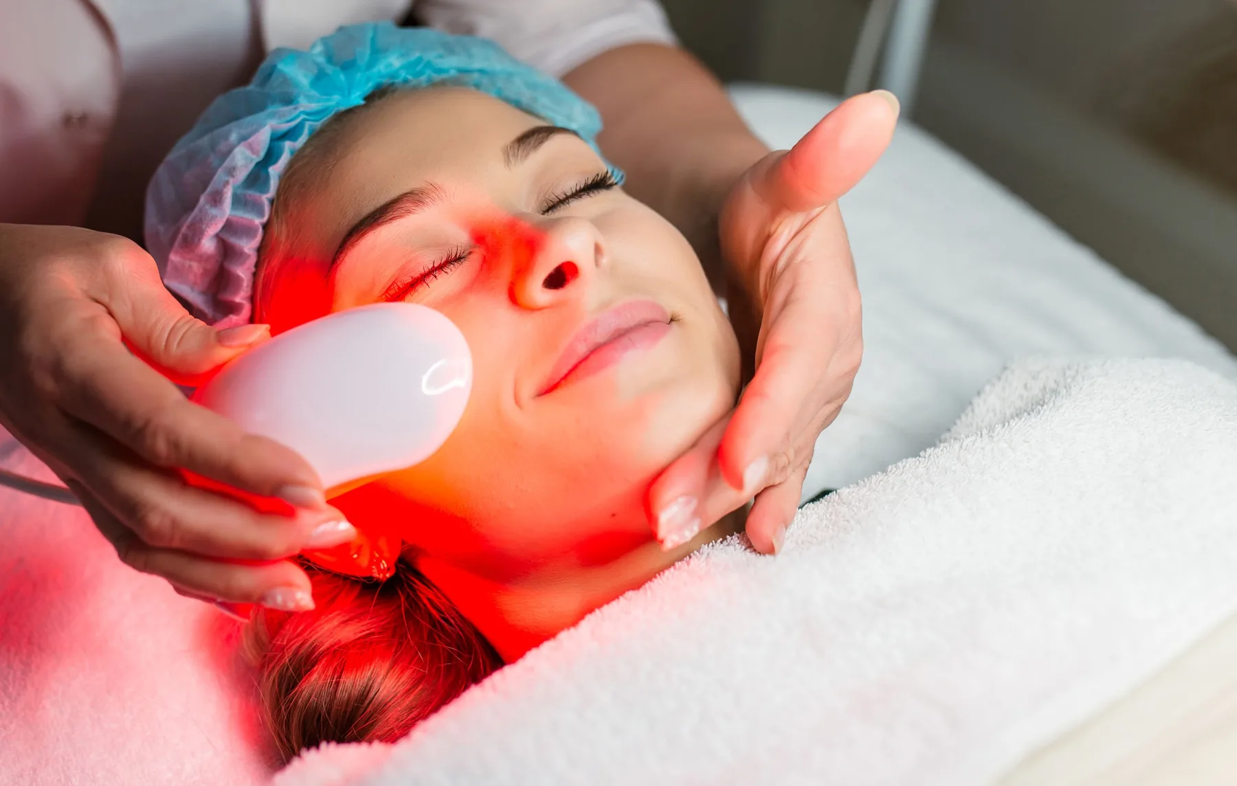 Handheld LED skin-tightening treatment on the cheek